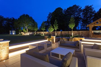 Contemporary and stylish patio garden at night with outdoor uprights, step lights, spotlights & exterior linear LED tape