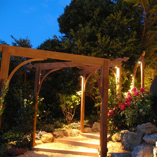 Warm LED downlights highlight a rustic outdoor pagoda