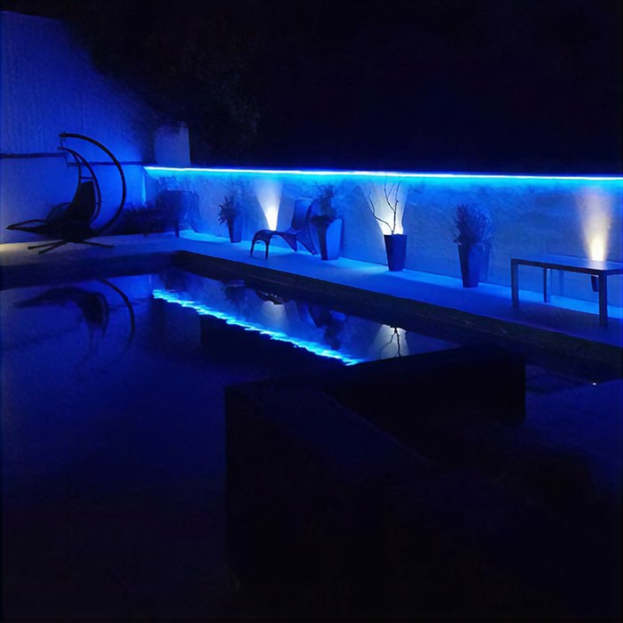 Moody blue lighting effect in a dark indoor pool room using Eleni Lighting EL501 linear profile cornices
