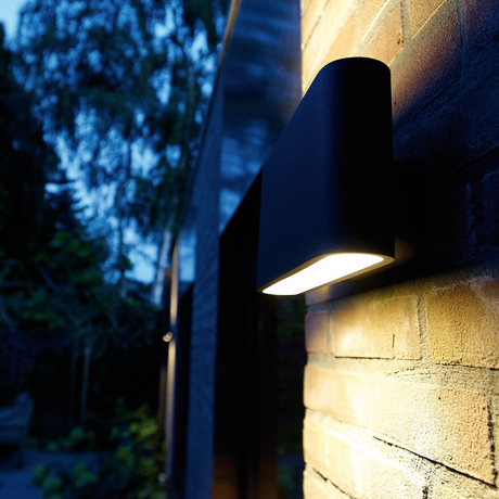 Outdoor contemporary wall light shining up & down a wall at night 