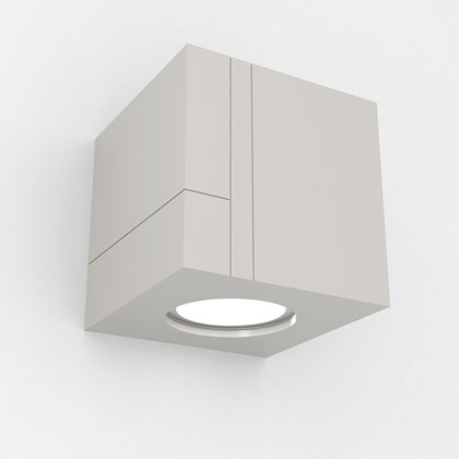 Nama Mondi Down Cube Wall Light switched on, set on a grey background