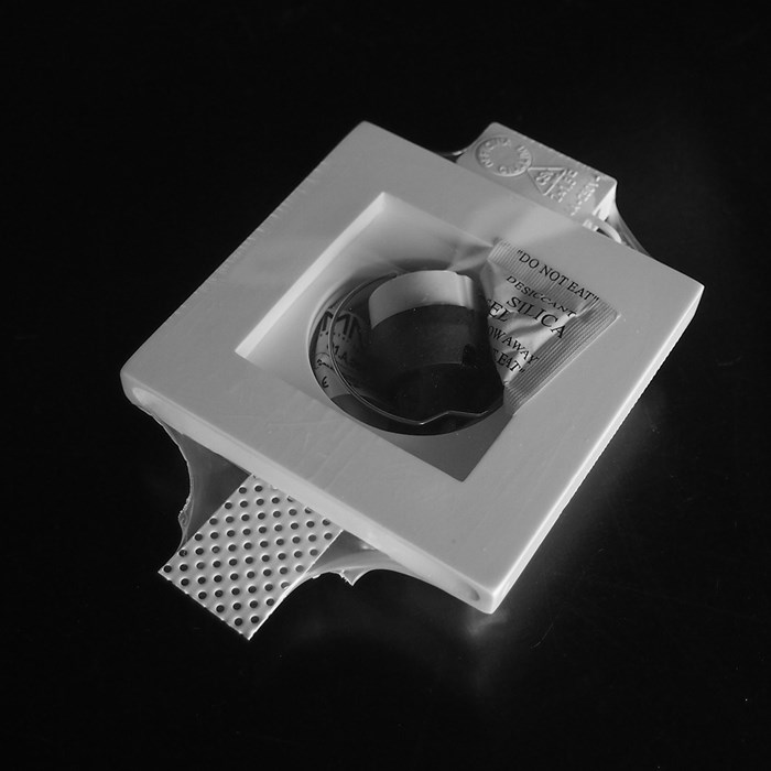 Nama Fos 01 Square Plaster In Downlight frame vacuum-packed on black background