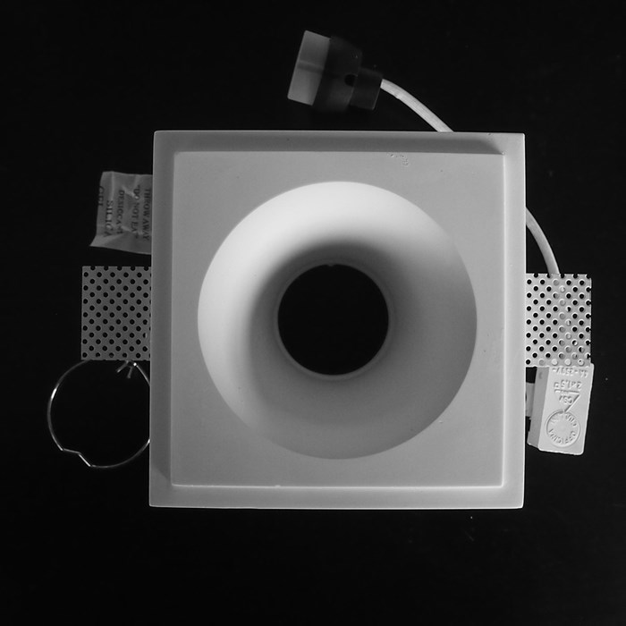 Component frame, lamp holder and fixings of the Nama Fos 04 Round Plaster In Downlight on black background