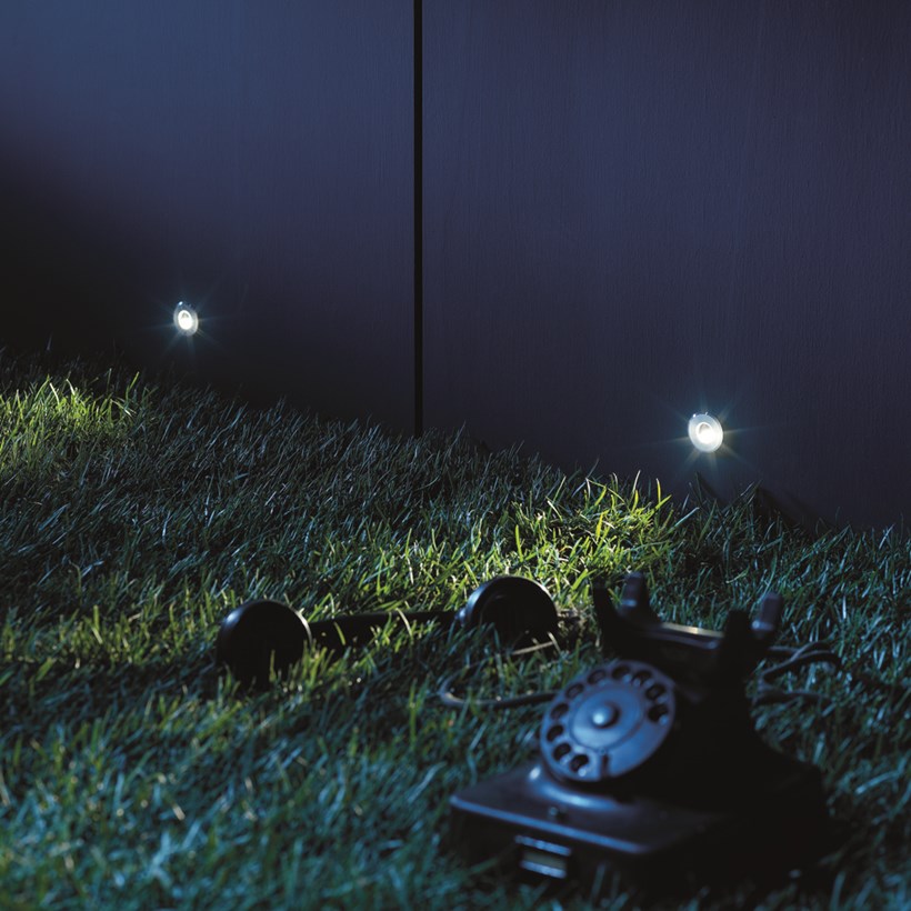 Mood shot image of two Flexalighting Bean LED Recessed Step Lights, illuminating a garden.