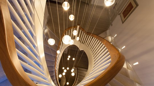 Our Design Process - birds eye view from above of a cluster of multiple Bocci glass orb pendants, suspended at various heights down a 3 story round staircase 