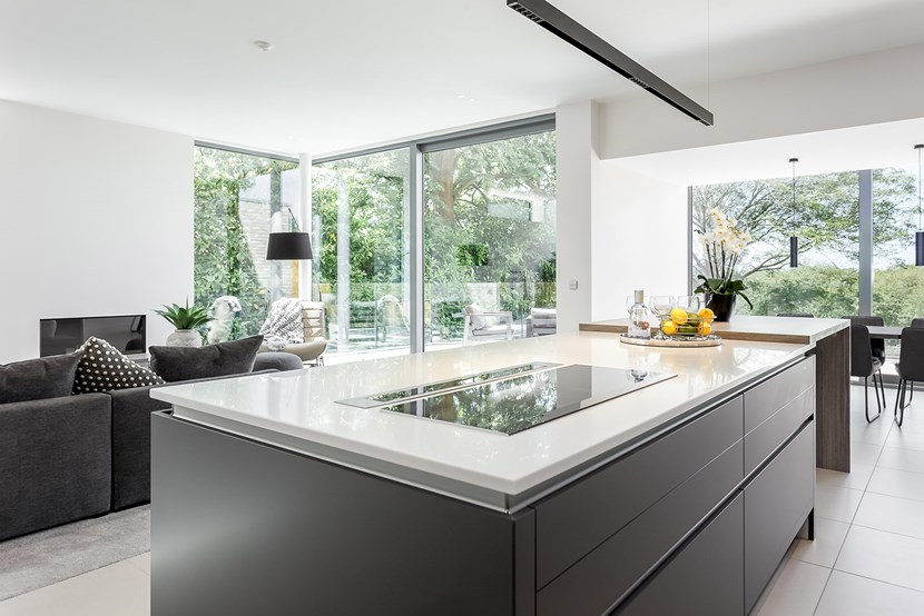 Lower view of DLD Shadowline LED track suspended over a kitchen island in a contemporary modern interior open plan living and kitchen space