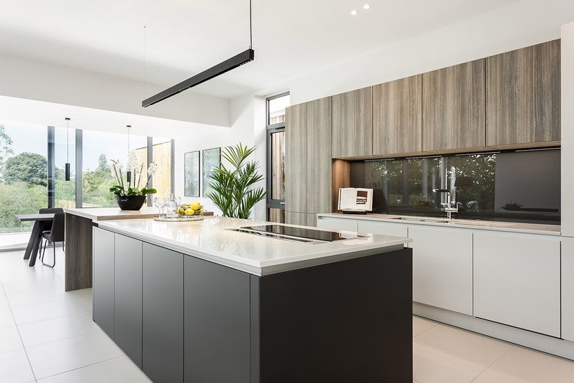 Wide shot of DLD Shadowline LED track suspended over the kitchen island in a contemporary modern interior open plan living and kitchen space