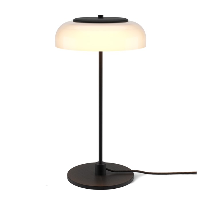 The Nuura Blossi Table Lamp in black, turned on.