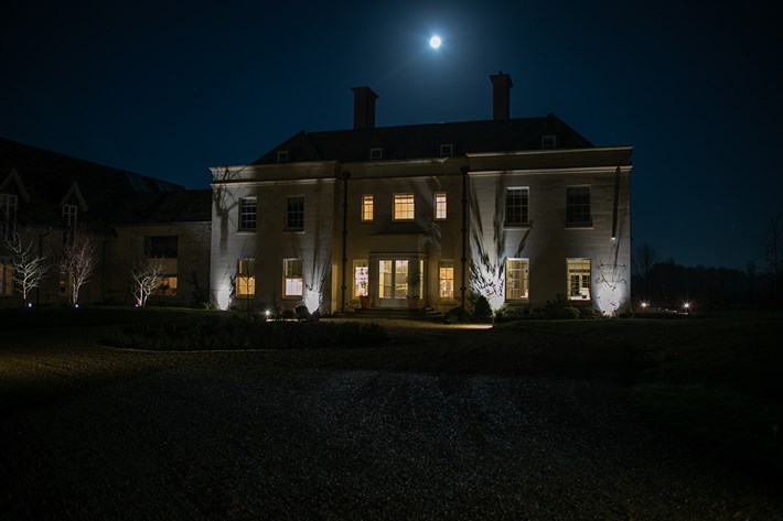 Lighting Design Pickwick outdoor shot of the front of the large country house at night, lit with uplights