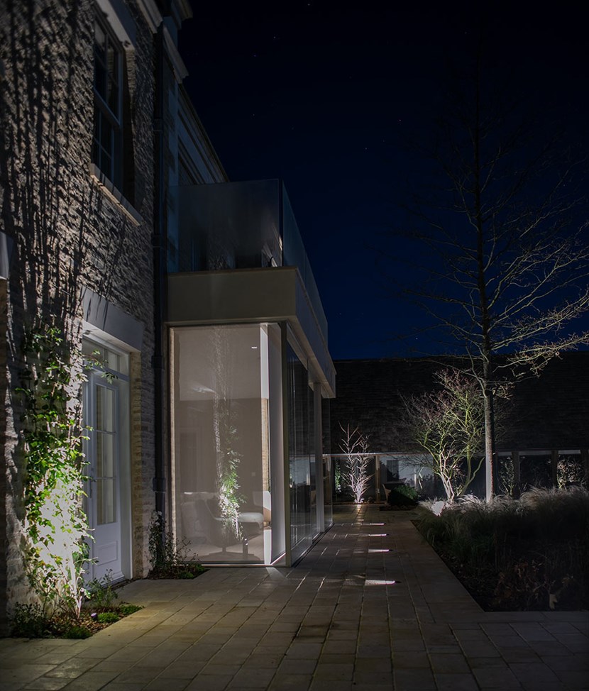 Lighting Design Pickwick outdoor shot of the beautifully landscaped garden, lit with uplights & pathlights