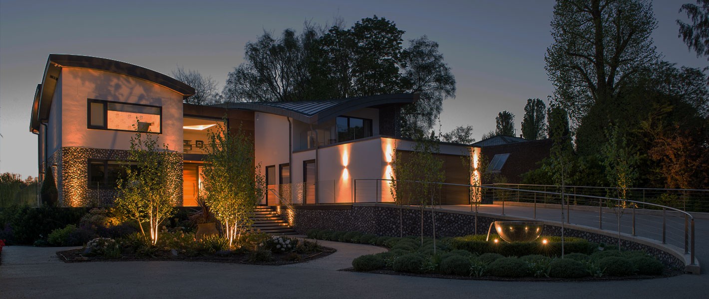 Modern house and front driveway lit up at dusk