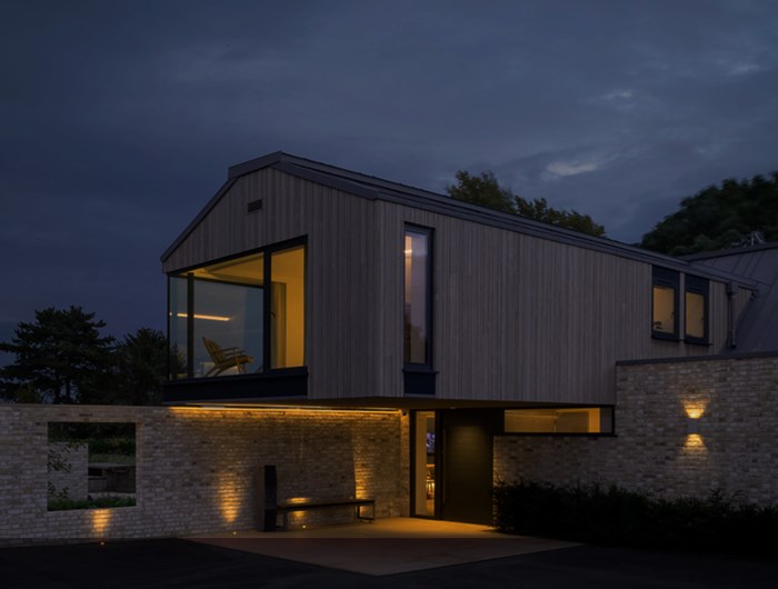 Modern minimalist cantilever house at night with smart home lighting