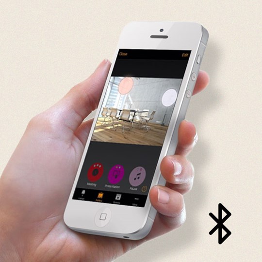 Bluetooth Lighting Control Systems: Hand holding a white smart phone with a lighting control app on the screen & Bluetooth icon in the corner