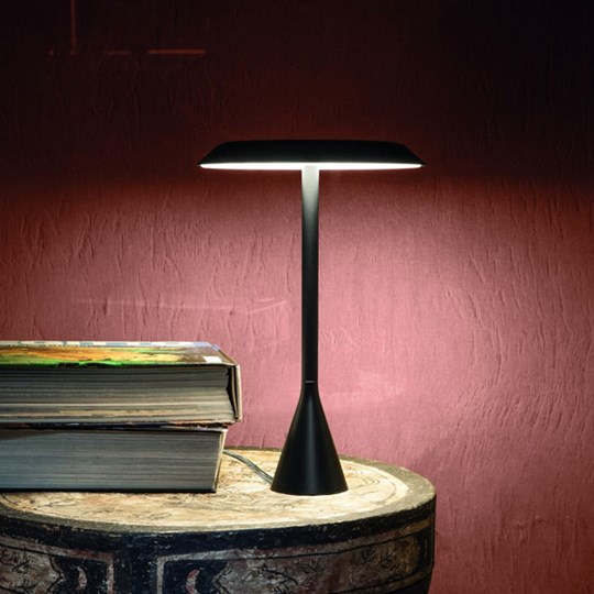 Table Lamps: Sleek modern black table lamp on rustic side table against a purple wall in the dark
