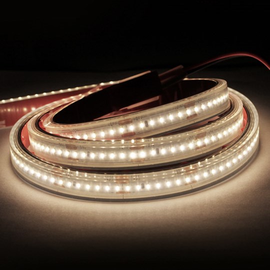 LED Tape: Roll of architectural LED strip with a warm white light switched on in the dark