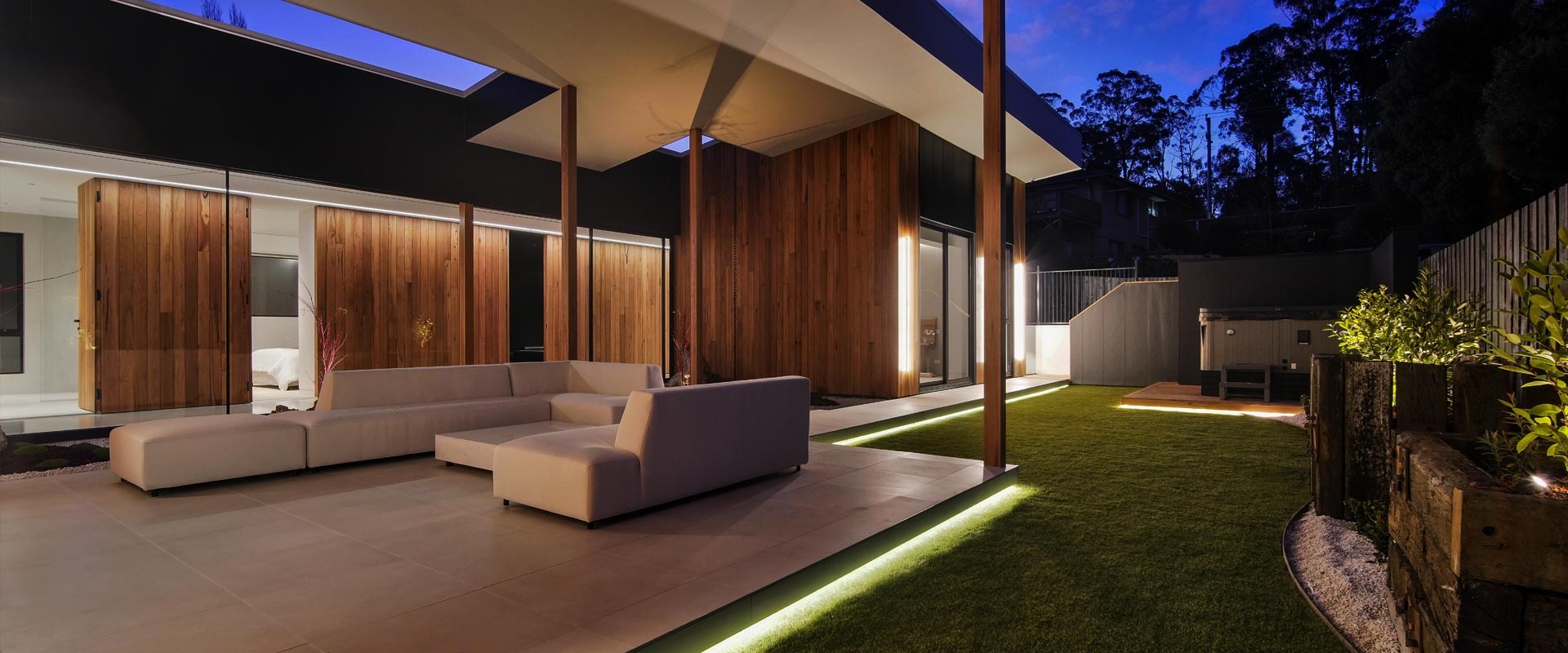 Outdoor garden of modern home - raised patio with strip LED step lighting 