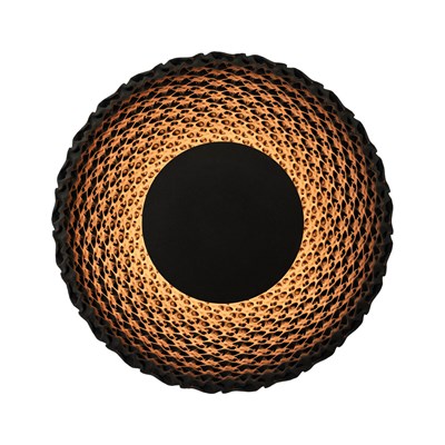 Large round wall light made from black quartz sand casting a soft, warm glow