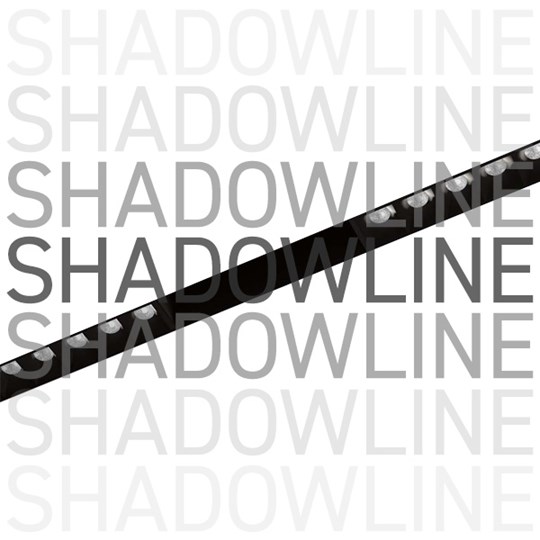Shadowline track with spotlight modules in black on white background, with overlaid typography