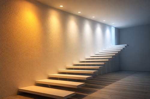 A series of downlights installed in the ceiling over a minimalist cantilever staircase. Each downlight is lighting in a different CCT, from 1800K candlelight, 2700K warm white through to 6500K daylight