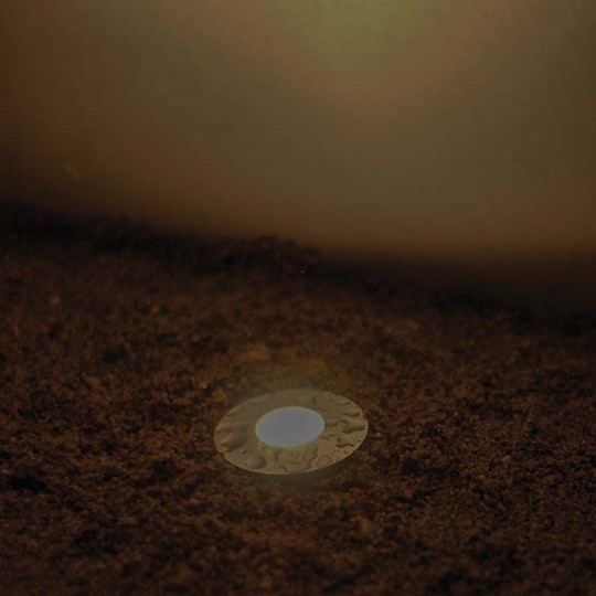 Outdoor Lighting: round floor recessed uplight with waterproof stainless steel finish, installed in the earth & lighting up a wall